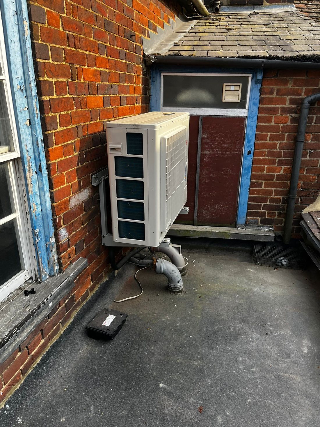 Air conditioning condenser unit on an external wall